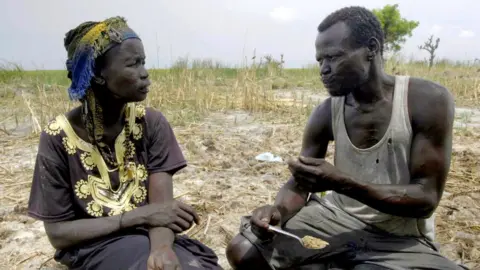 BBC Nyakuma and her husband Sunday sitting in the grass