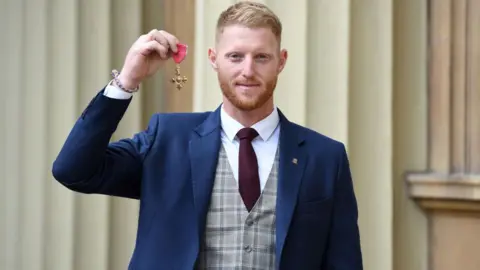 Getty Images Ben Stokes in a suit with his OBE medal at Buckingham Palace.