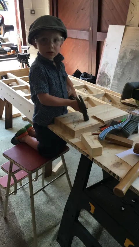 Emma Eltham Alfie, aged four, with a toy drill in a workshop.