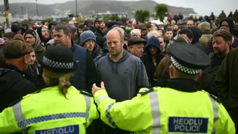 Getty Images A group of people facing police in Llandudno