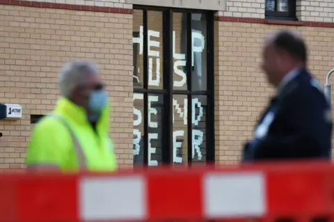 PA Media A sign saying "help us, send beer" in a window at Murano Street Student Village in Glasgow, where Glasgow University students were being tested at a pop up Covid test centre in September, 2020