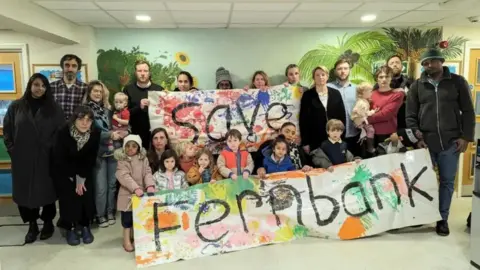 Save Hackney's Children's Centres Campaigners hold a sign saying "Save Fernbank"