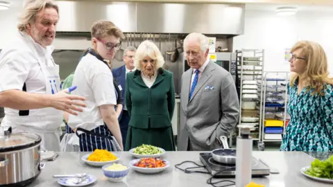 Reuters The King and Queen in a kitchen marking the launch of a project to use surplus food, at an event in Didcot in Oxfordshire in November 2023