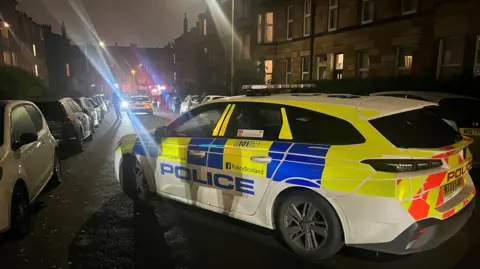 Two police cars parked on a busy street