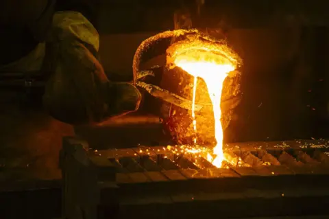 Getty Images A worker pours molten gold into a mould during the refining of bullion at a plant in South Africa, on 16  August 2017