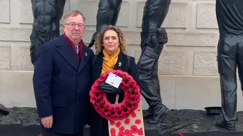 Instagram Hannah and Colin Ingram-Moore holding a poppy wreath at the National Arboretum