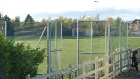 Google Green AstroTurf with high wire fencing all around it.