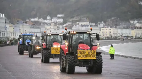 Getty Images Farmers driving on Llandudno promenade with a sign on the front saying Labour War on Countryside