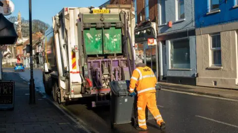 Getty Images A council bin worker empties bins into a lorry in Ipswich, Suffolk