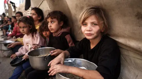 AFP Palestinian children collect aid food at Bureij refugee camp in the central Gaza Strip (6 November 2024)