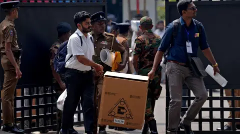 Reuters Polling officials and police officers carry election materials after collecting them from a distribution centre 