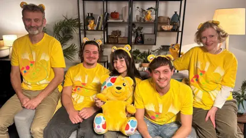 BBC The cast of Outnumbered sitting on a sofa wearing yellow Children In Need T-shirts and Pudsey ears, with a Pudsey cuddly toy